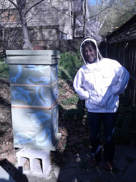 Laura shows off the new paint scheme of the hives while trying on a beesuit